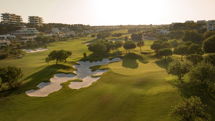 Fairway og bunkere på Las Colinas i lavt kveldslys, med villaer i åssiden bak