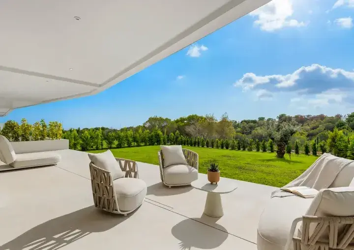 Overbygd terrasse på en villa på Las Colinas, med utemøbler og hagen bak